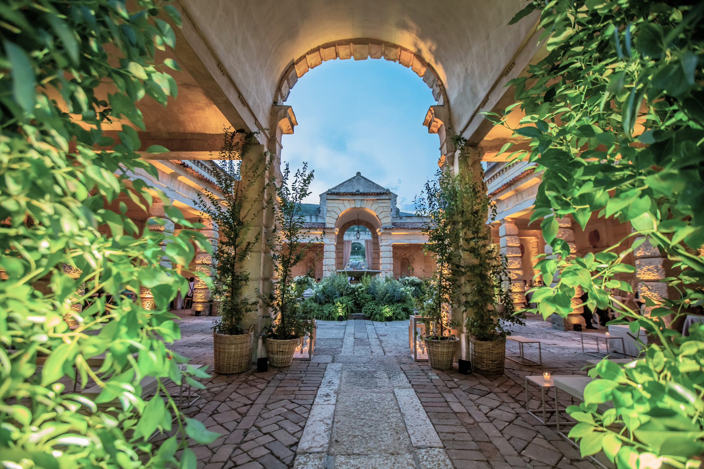 Arco di pietra che si apre sul giardino della villa